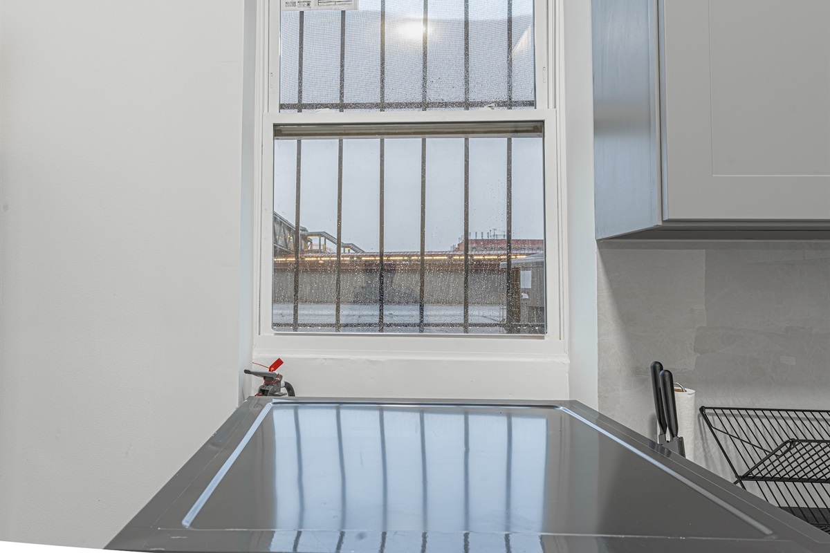 Big windows pour natural light over the kitchen counter — bright, airy, and welcoming all day.