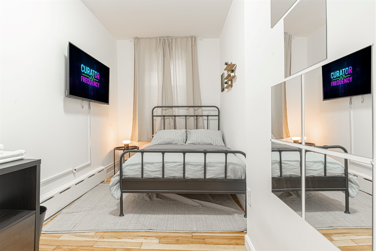 Inviting bedroom with bedside lighting and soft curtains — a peaceful place to recharge.