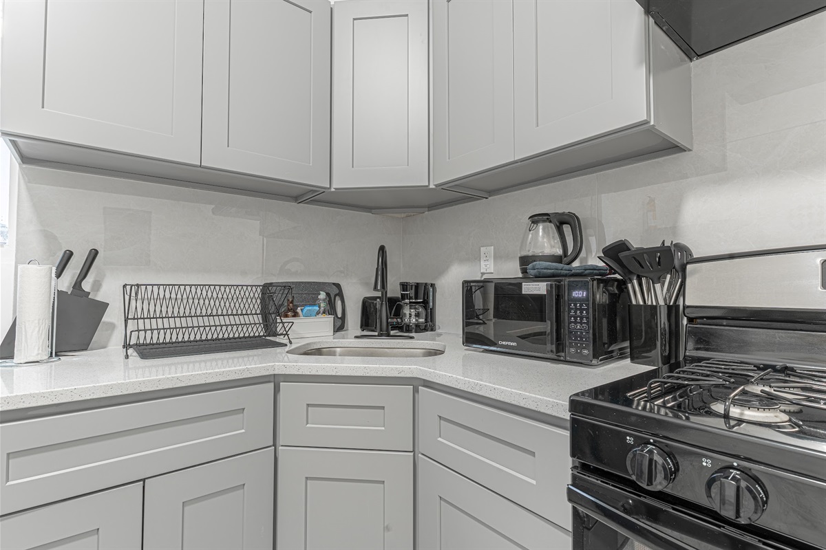 Modern kitchen corner with ample counters and full-size appliances — tidy and ready for your stay.