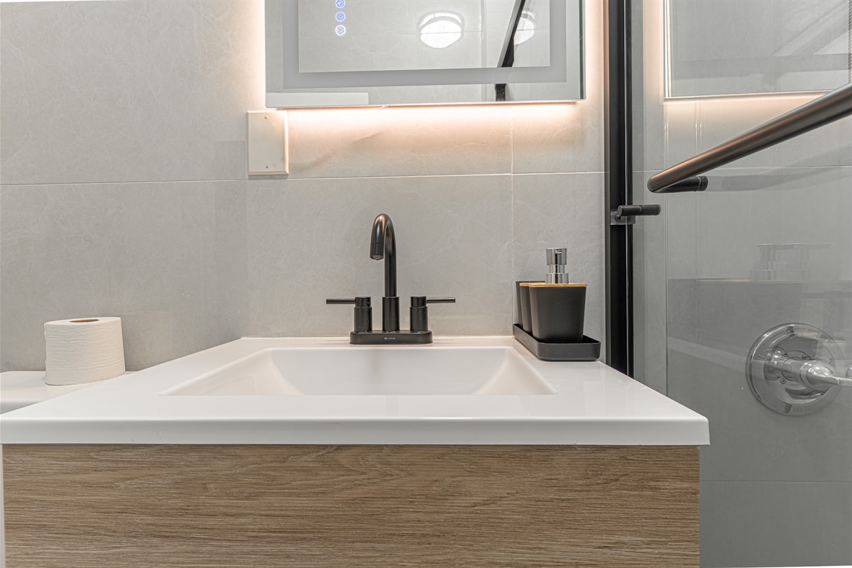Spotless bathroom with glass-enclosed shower and stocked vanity — comfortable and move-in ready.