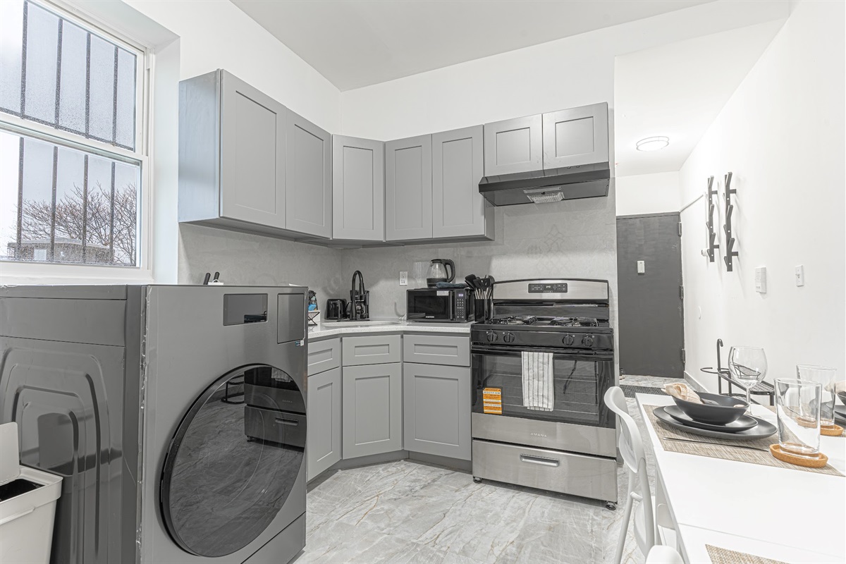 Full kitchen with gas range, generous cabinets, and in-unit washer — cook and stay comfortable in Queens.