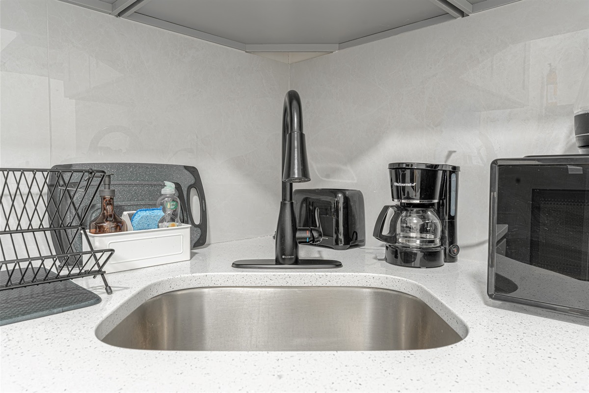 Clean kitchen with deep sink, coffee maker, and microwave — everything you need to fuel up each morning.