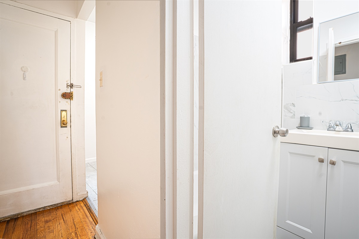 Entry view with access to bright, modern bathroom and sleek vanity
