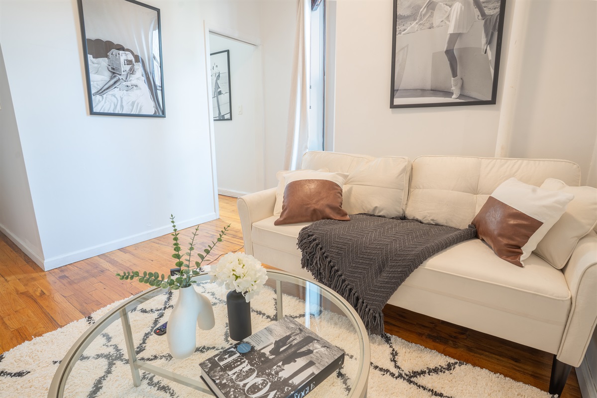 Cozy living space with plush sofa, art, and glass coffee table