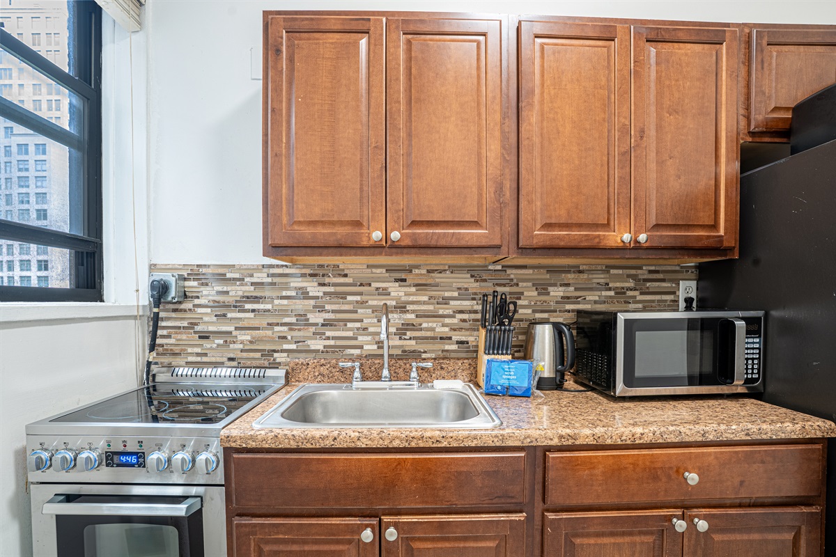Well-equipped kitchen with stove, microwave, and essentials