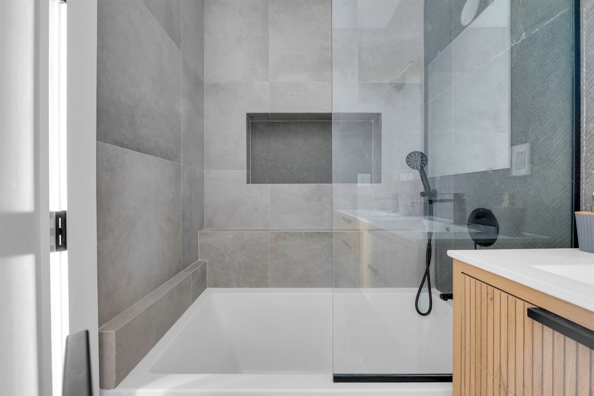 Spotless walk-in glass shower with floor-to-ceiling tile — refresh after a day exploring the city.