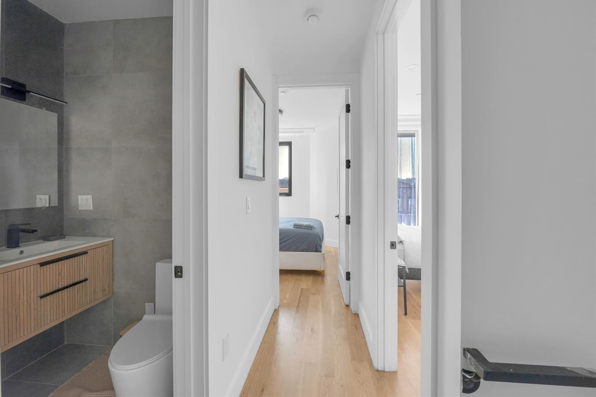 Bright hallway leading past the bath toward the bedrooms of this modern retreat.