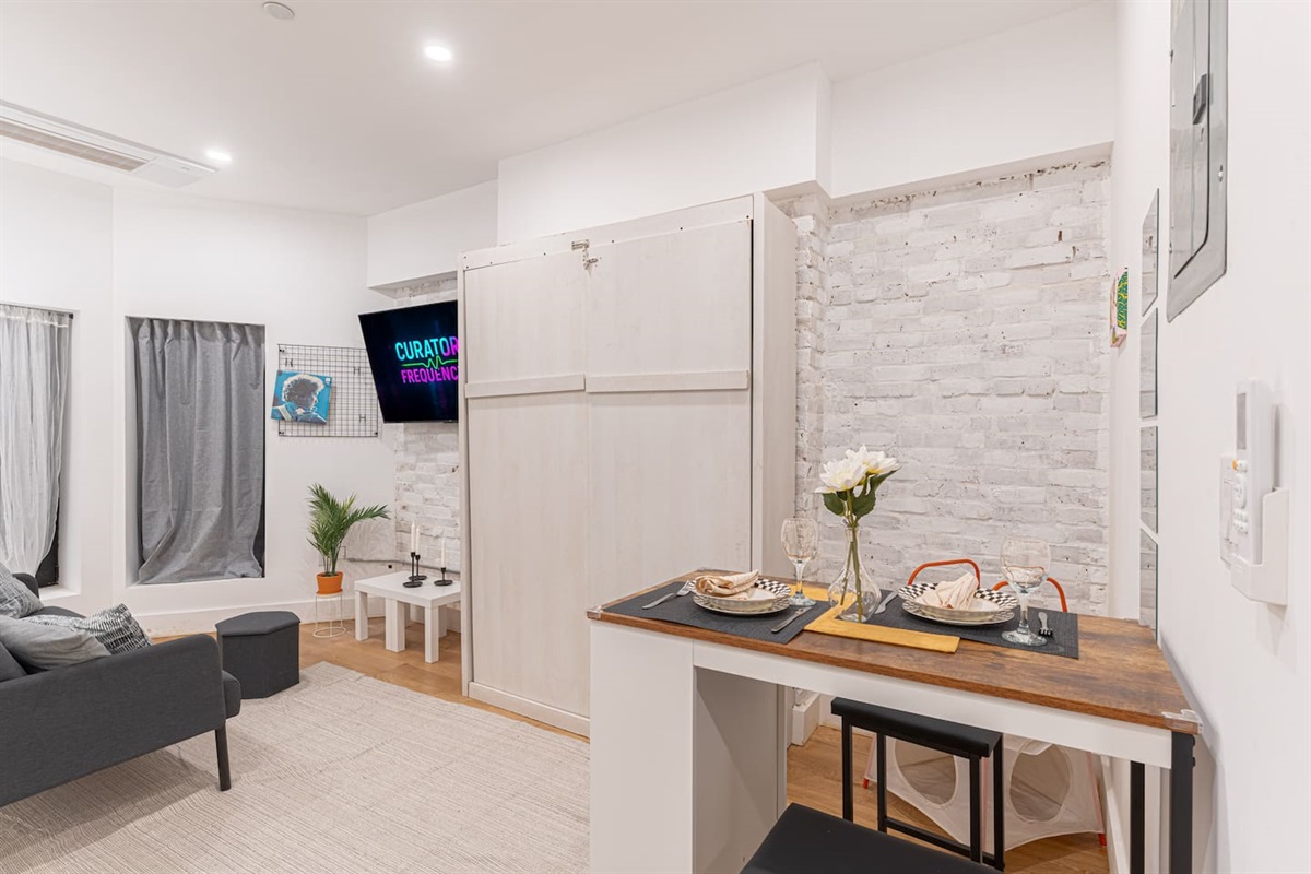Sleek kitchen-and-dining nook with a wood counter set for two and full appliances — cook, eat and relax in this smart st
