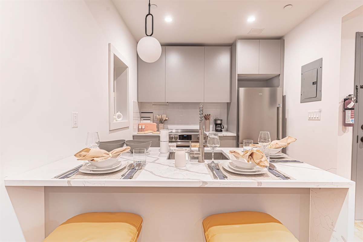 Modern kitchen with dining bar overlooks airy living room for easy entertaining.