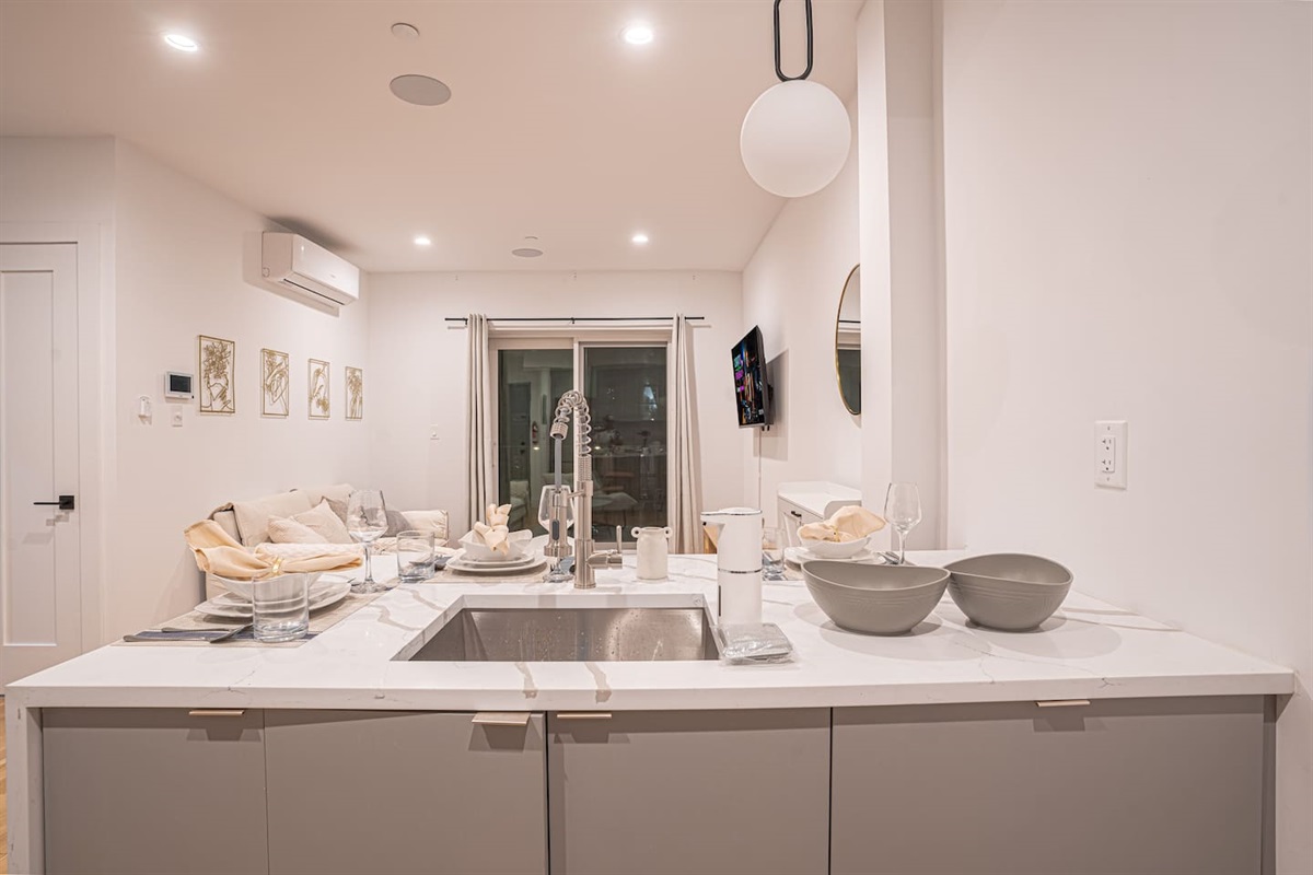Modern kitchen with dining bar overlooks airy living room for easy entertaining.