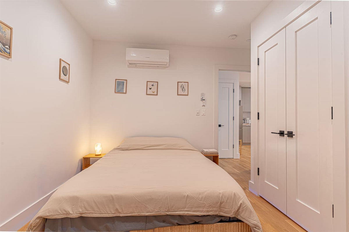 Japandi-style bedroom with queen bed, warm woods and soft linens offers a peaceful retreat.