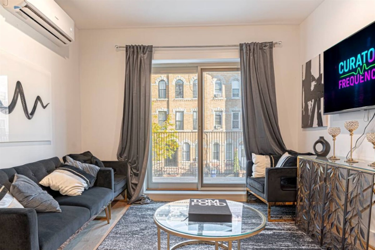 Bright living area featuring Japandi design, comfy sofa, smart TV and direct access to balcony