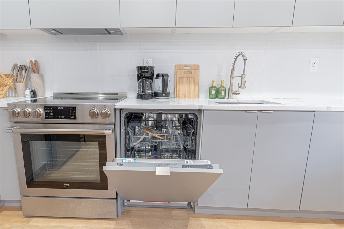 Cook with ease in a sleek, modern kitchen featuring stainless oven/range, dishwasher, and a deep sink with pull-down fau