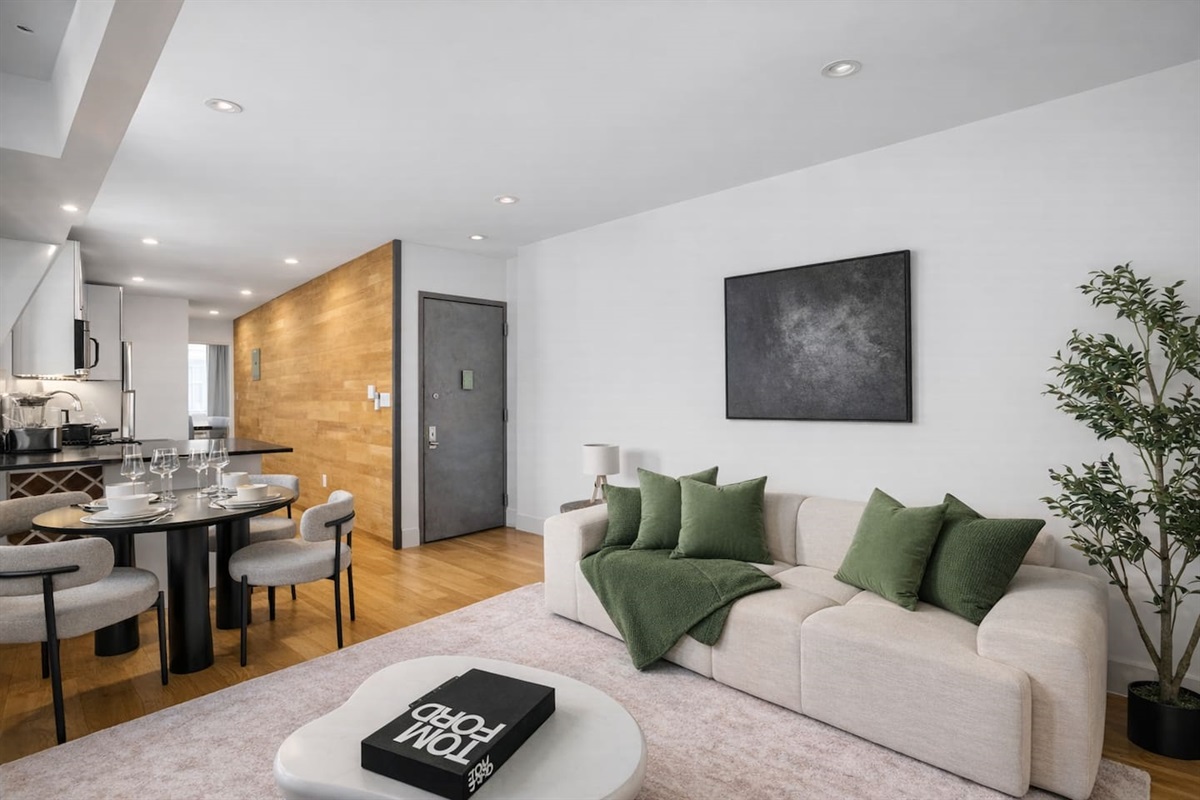 Open-plan dining and kitchen with a round table for four, warm wood accents and an airy layout — gather and dine in this