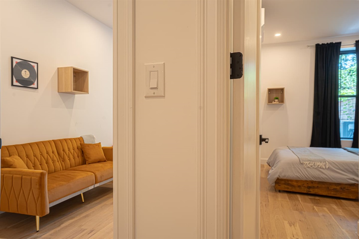 Bright hallway connecting living area and bedroom with clean lines and warm wood flooring