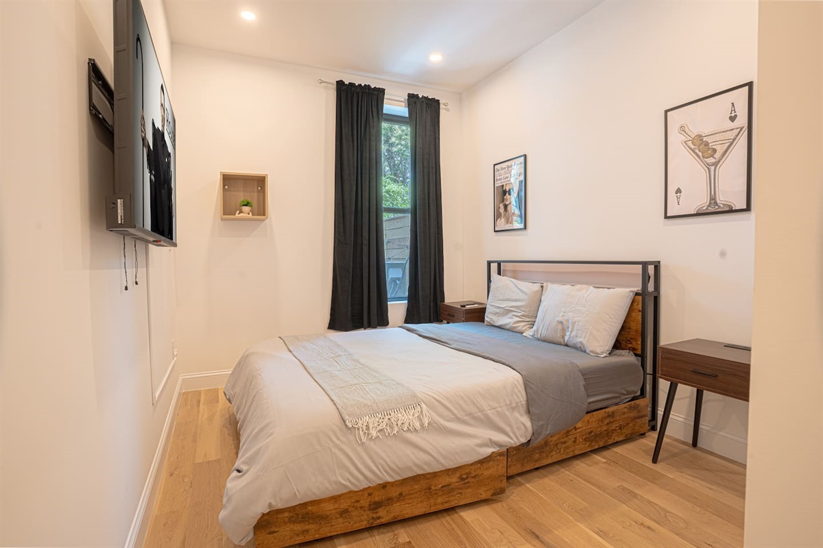 Sunny bedroom with queen bed, TV and modern rustic charm blending warmth and contemporary style