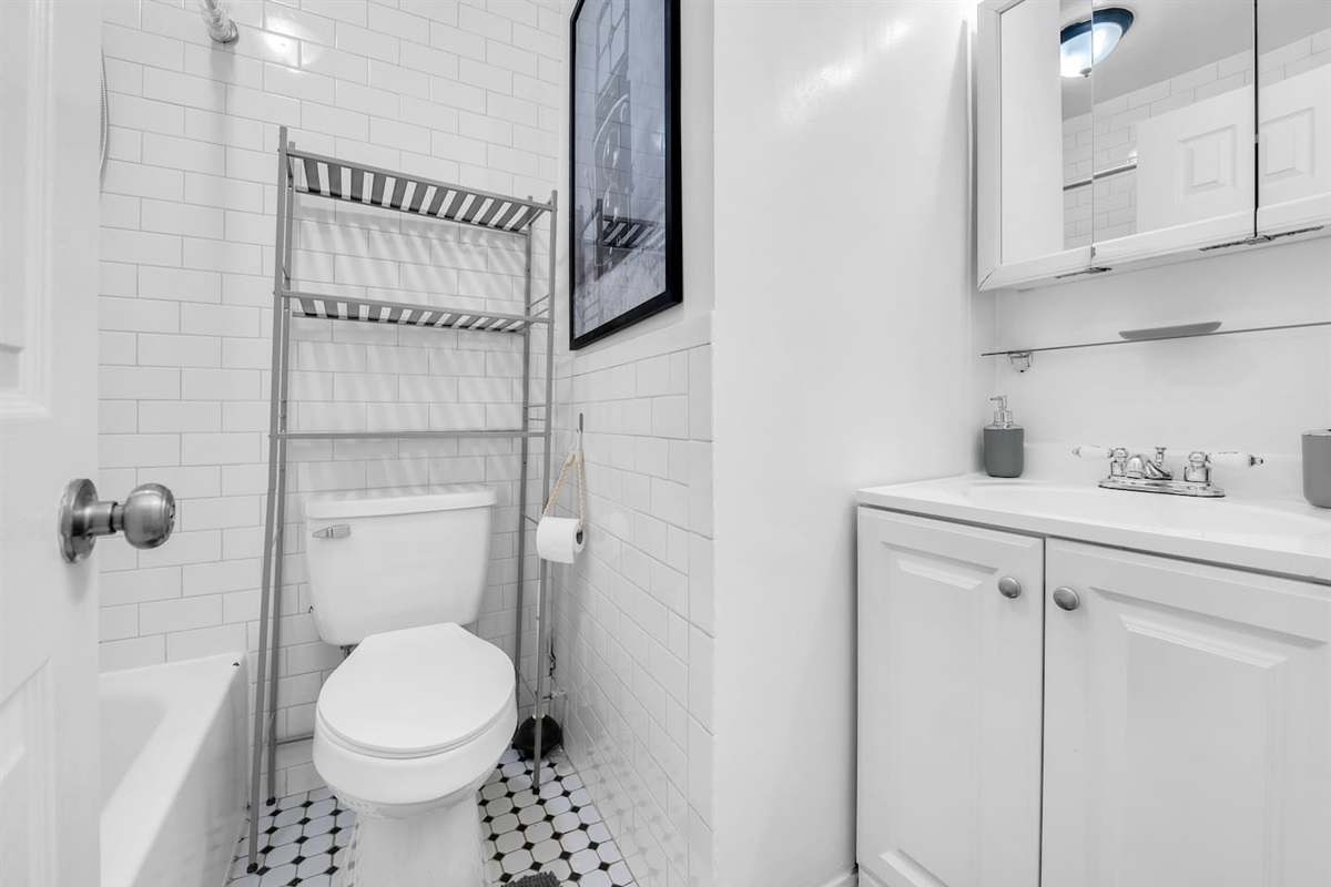 Clean, modern bathroom with classic subway tile and hex flooring — fresh towels and toiletries provided for your arrival