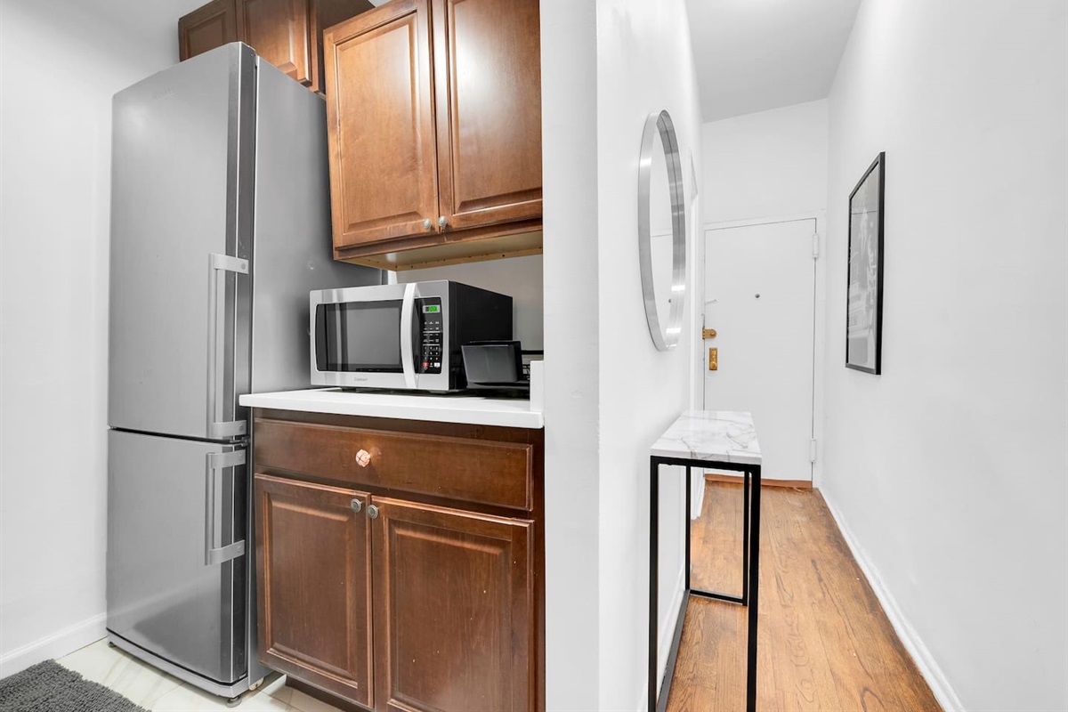 Kitchen with full-size refrigerator, microwave, and generous storage — fully equipped for short or extended stays.