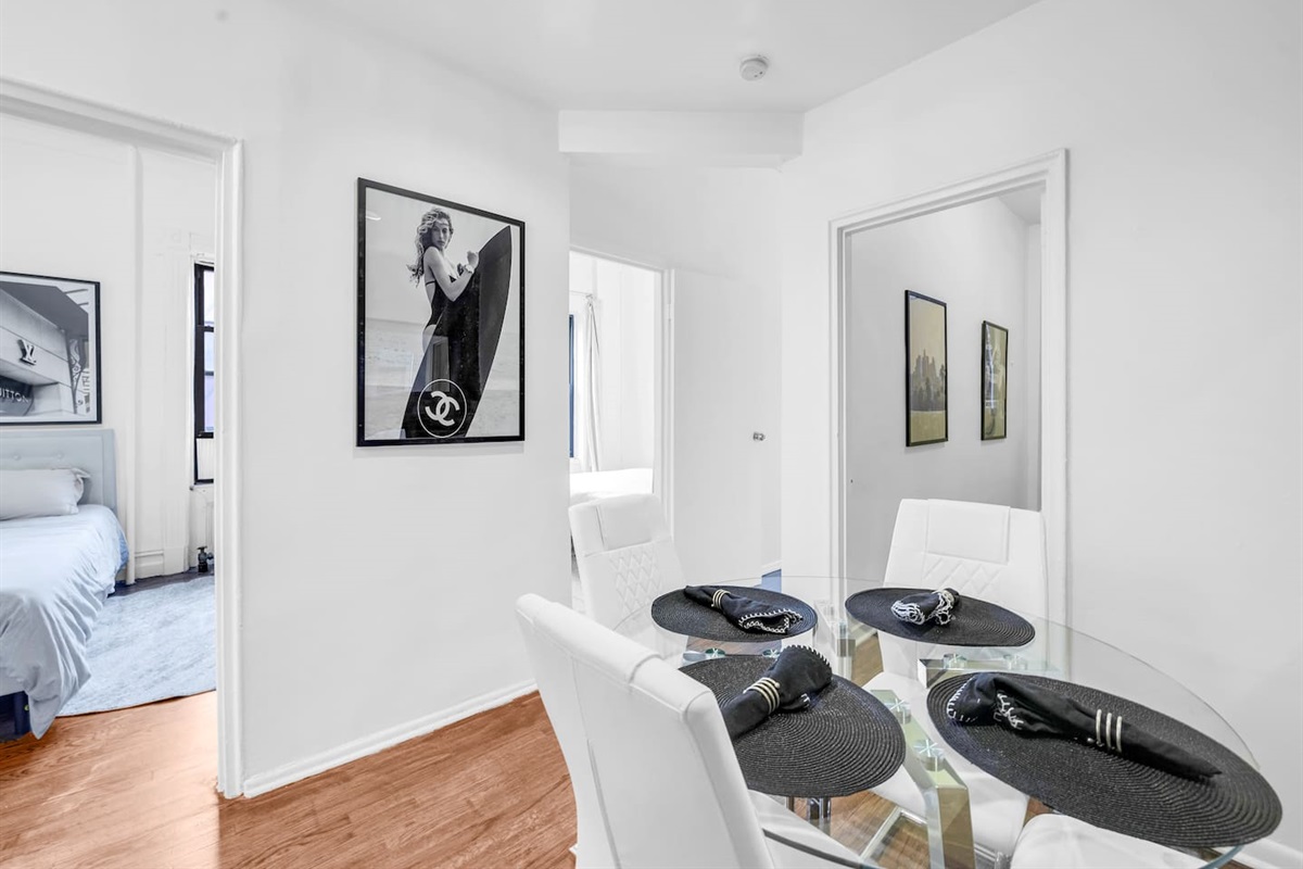 Inviting dining area with a glass table that seats four — gather for meals, games, or remote work together.