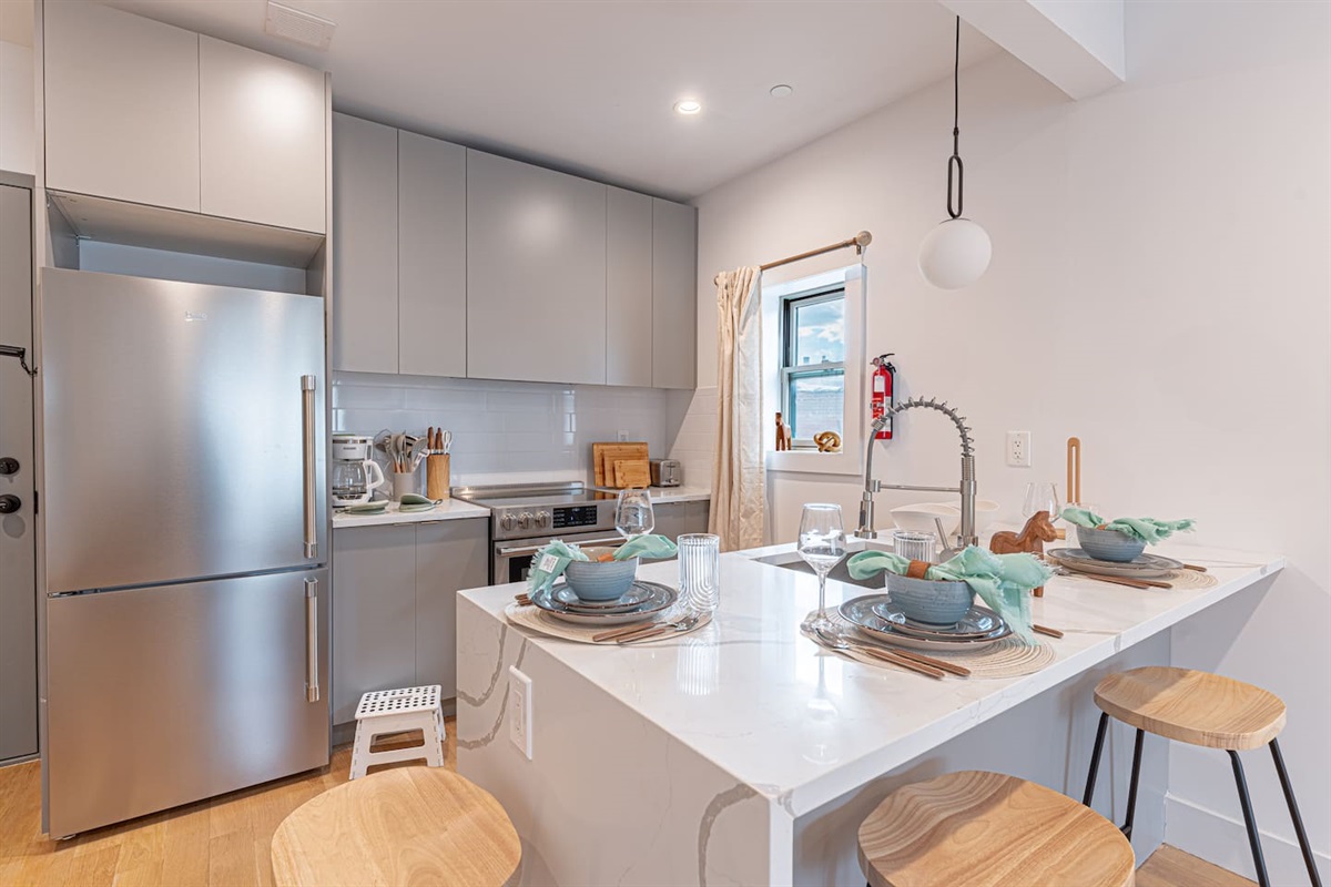 Kitchen nook with dining bar and modern appliances in bright Scandinavian Bushwick 1BD