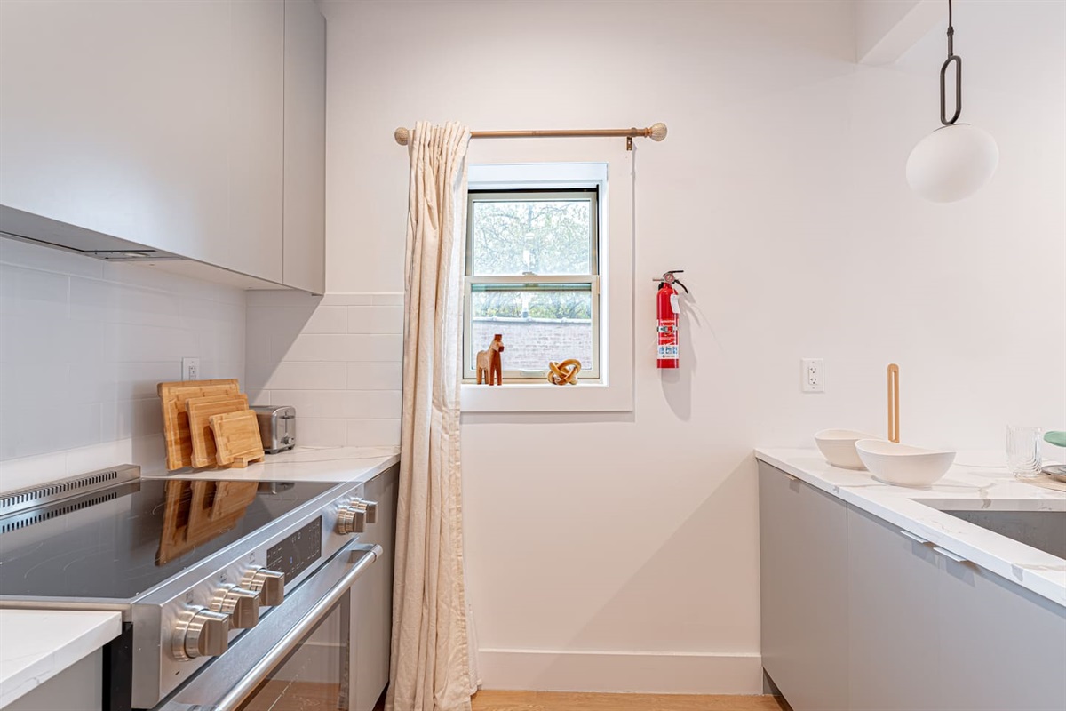 Kitchen nook with dining bar and modern appliances in bright Scandinavian Bushwick 1BD