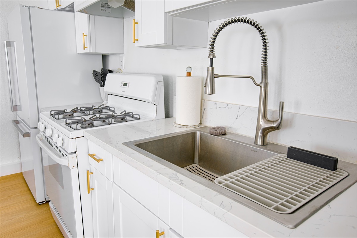 Modern kitchen with stainless sink, gas range, and generous prep space — fully stocked for your stay.