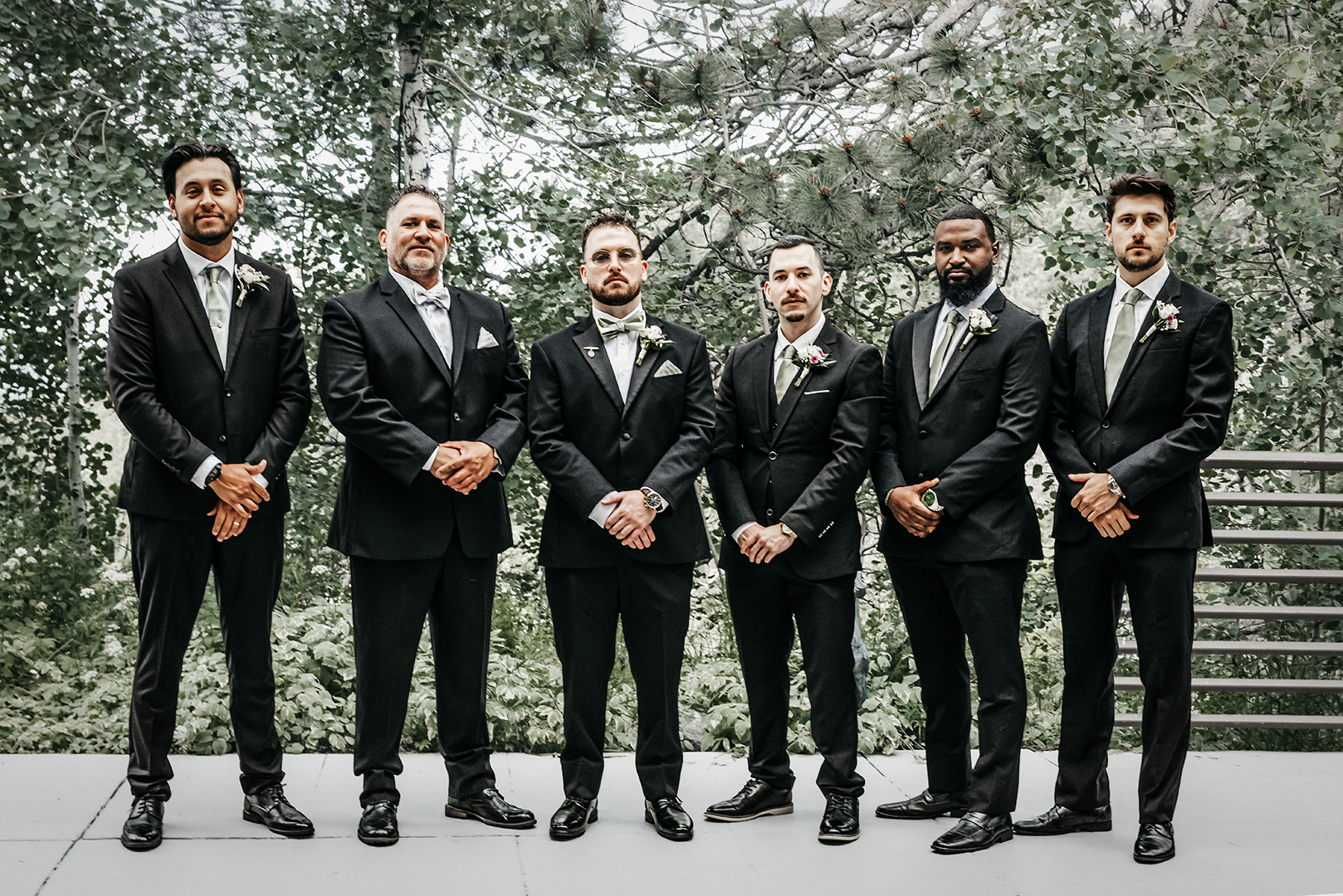 A group of groomsmen with all brothers and a father standing together before a wedding with backdrop of Aspen trees