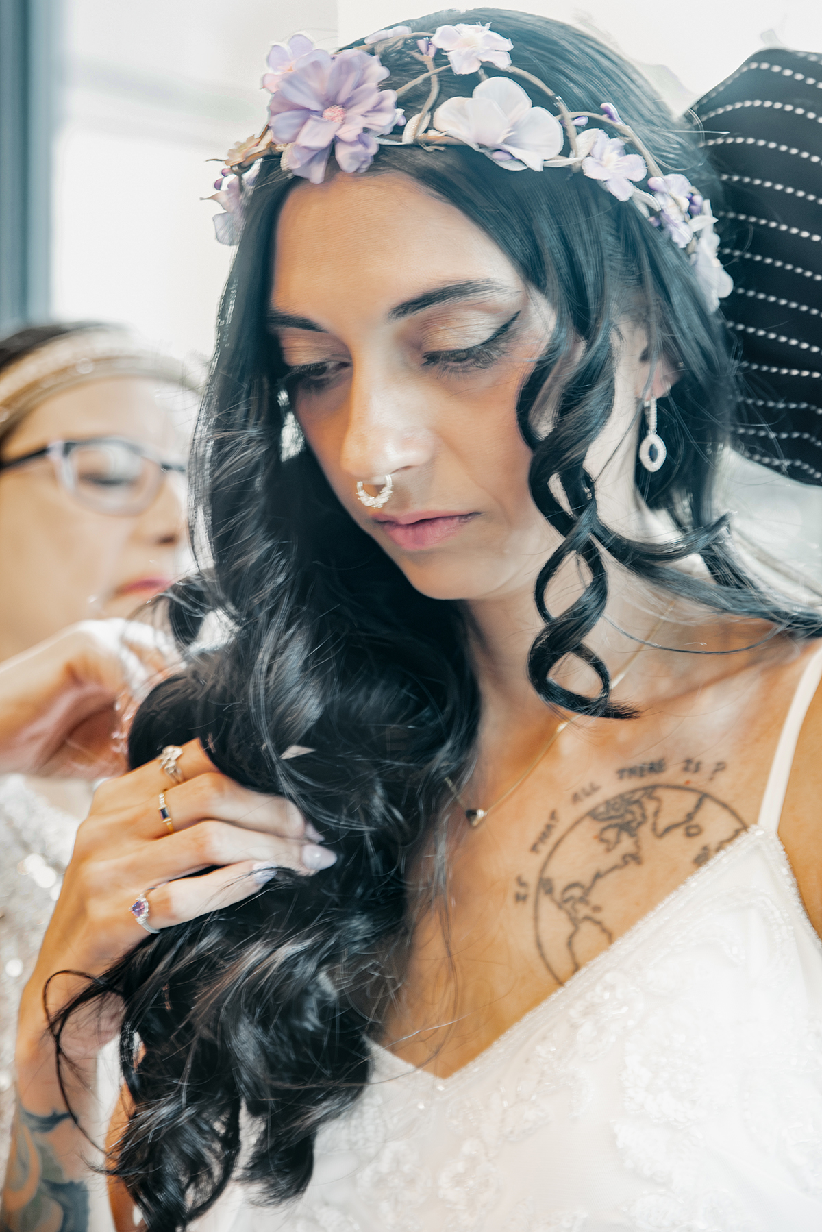 A mother helping her daughter with her final details before she walks the isle to her wedding. 