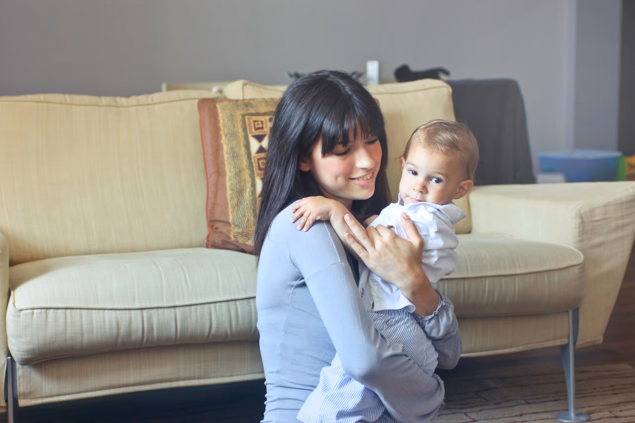 Femme portant jeune enfant dans ses bras, équilibre parentalité travail, soutien collaborateurs entreprise