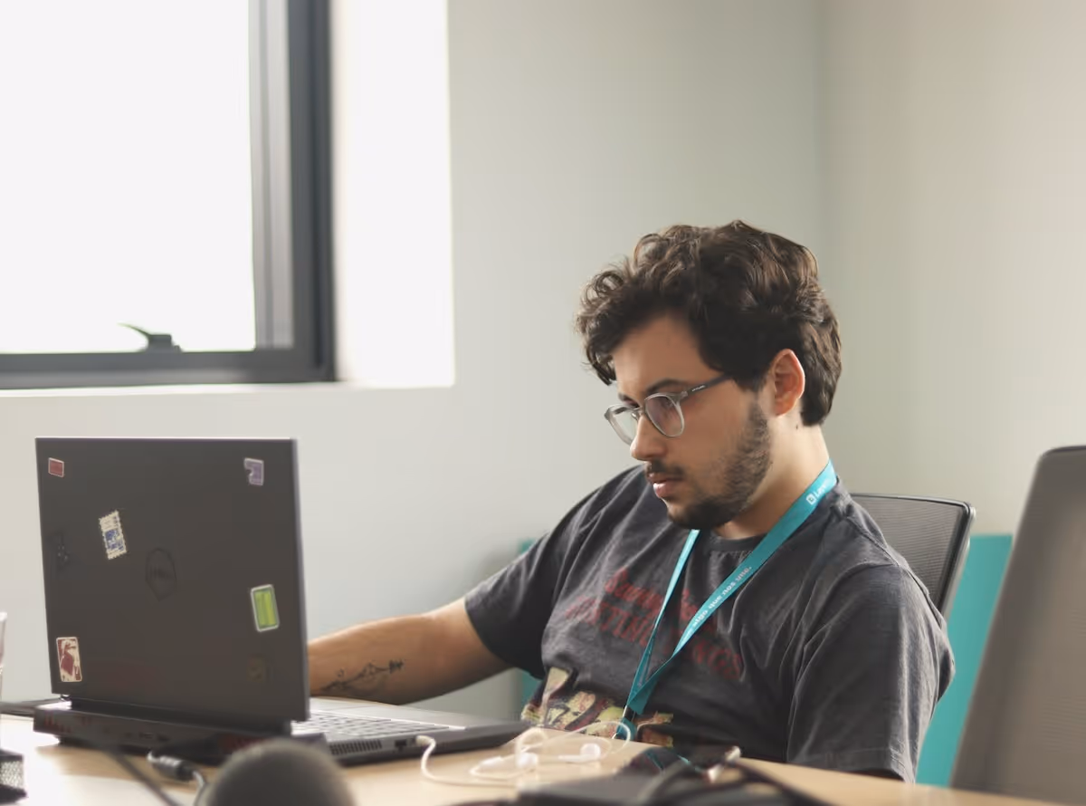 Un salarié au bureau devant son MacBook Pro et son smartphone