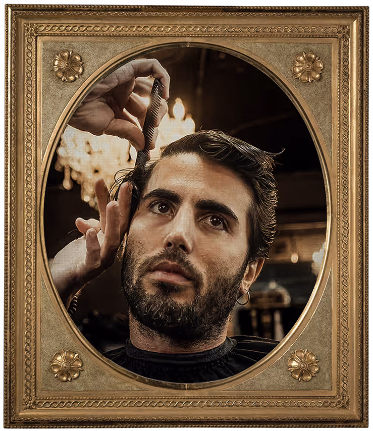 Man receiving a classic haircut, with a barber combing his wet hair in a stylish barbershop.