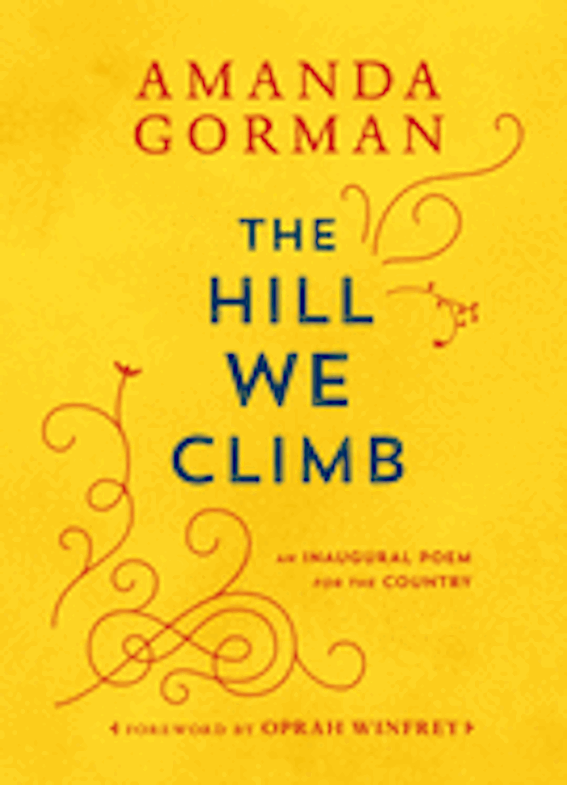Cover of a book titled The Hill We Climb. The book cover is yellow and the words are written in blue. There are red design elements on the cover as well.