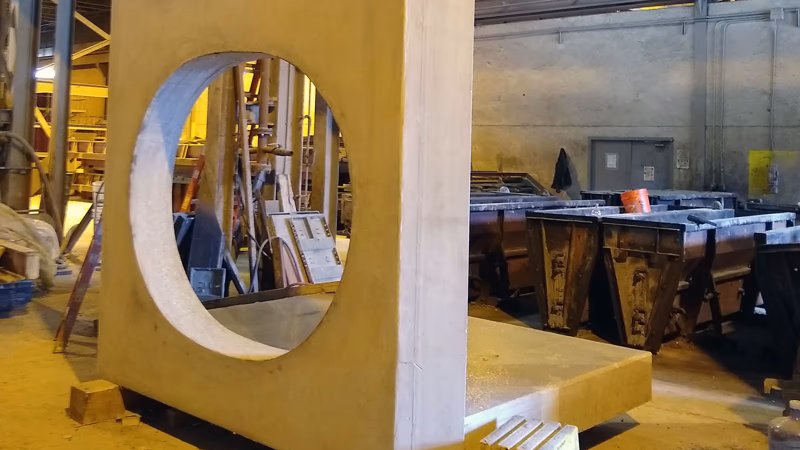 Large concrete structure with a circular opening in an industrial workshop.