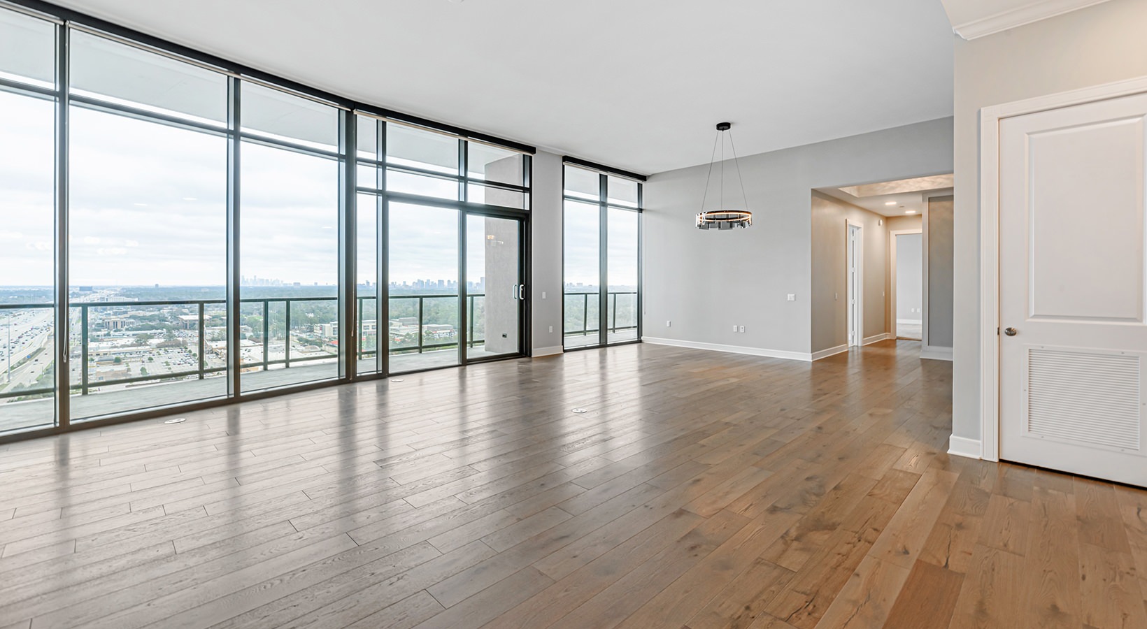 Rooftop patio with a clear view of the Denver city skyline from The Julian penthouses in Sloans Lake, featuring outdoor seating and planters.