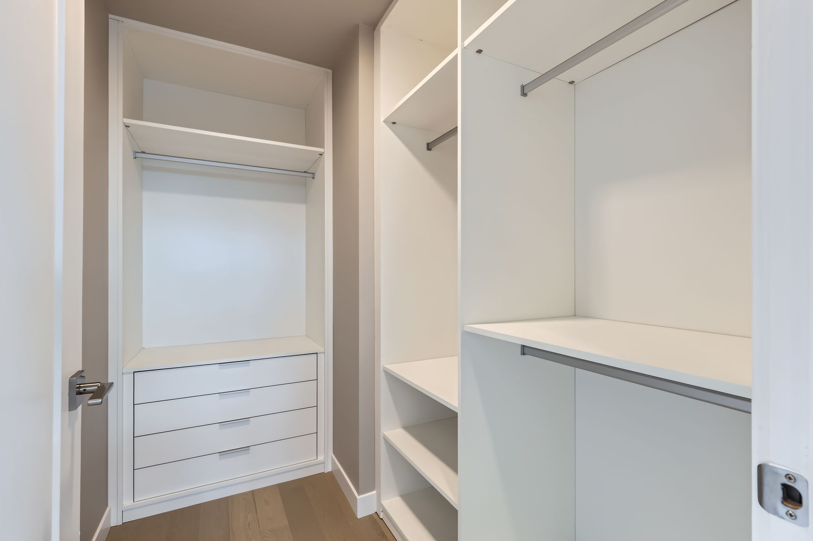 Spacious walk-in closet with custom white shelving and built-in drawers in a luxury apartment at The Julian in Sloans Lake, Denver.
