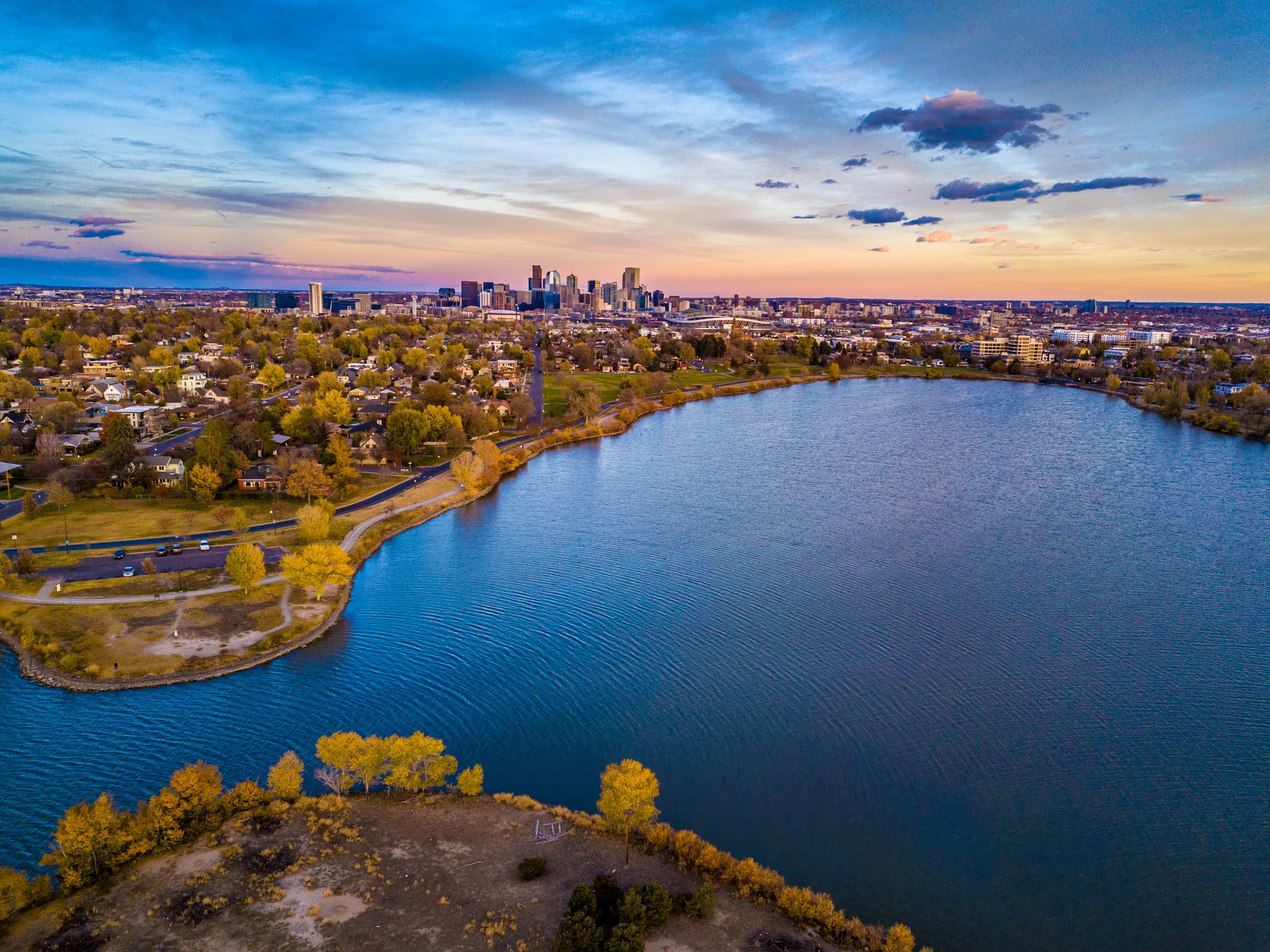 Aerial view of Sloan's Lake and downtown Denver skyline at sunset near luxury apartments in Denver, CO