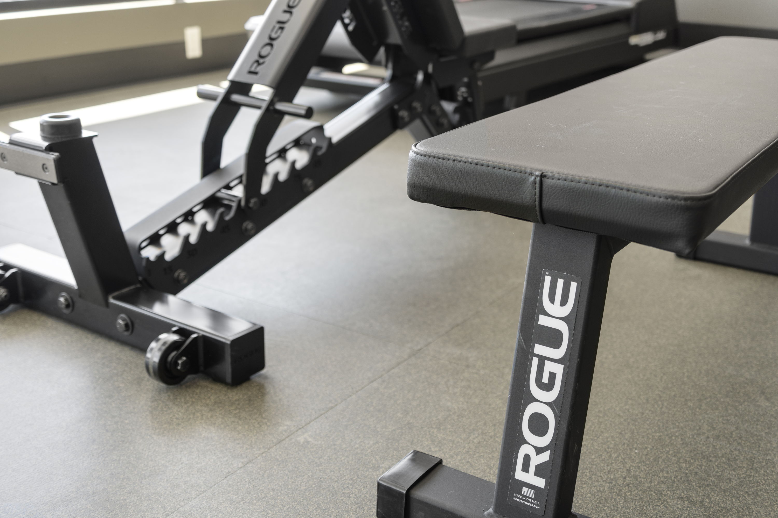 Well-equipped fitness center at The Julian apartments in Sloans Lake, Denver, CO, featuring cardio machines, weights, and large windows with city views.
