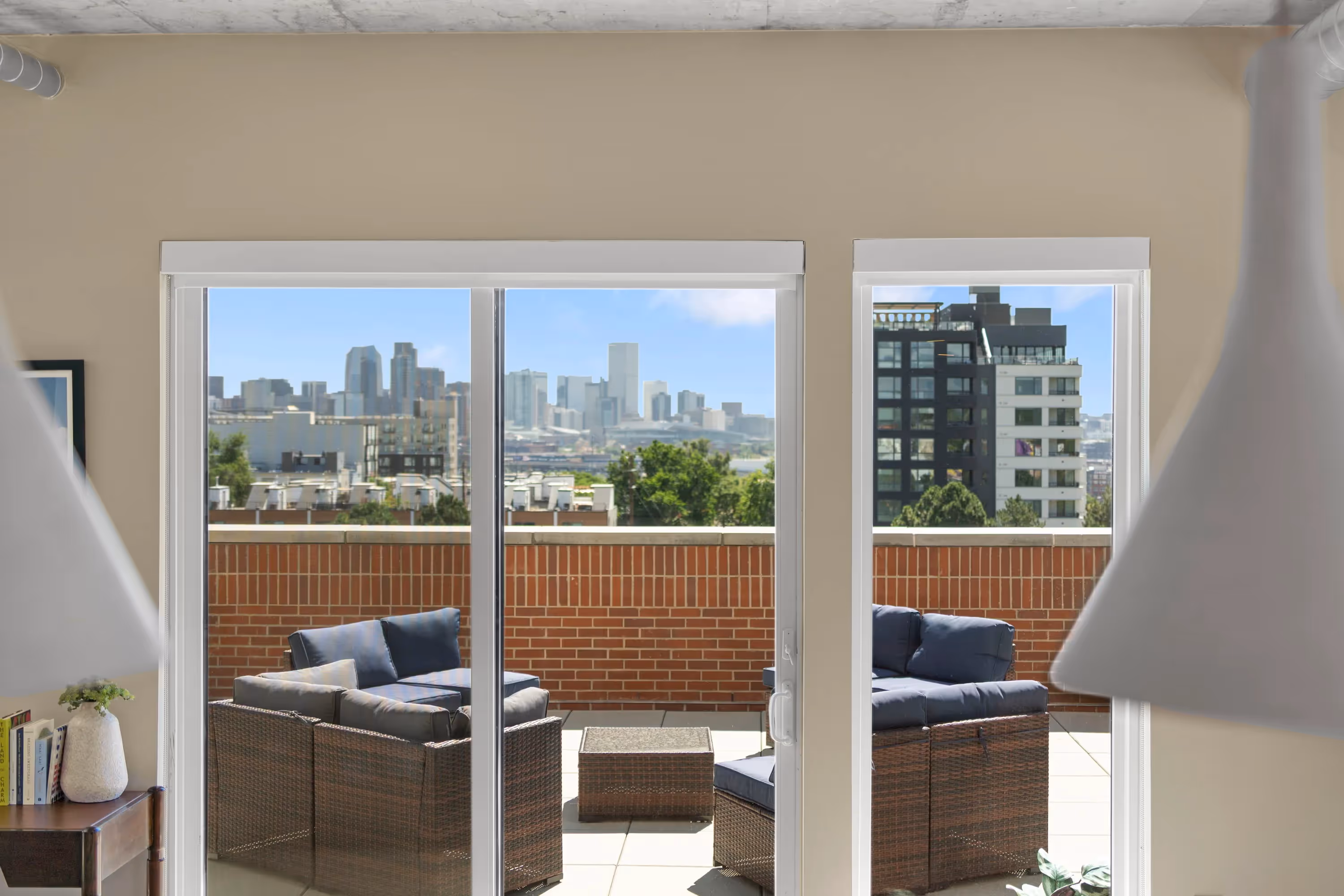 Expansive open-concept living room and kitchen in a luxury apartment at The Julian in Sloans Lake, Denver, with concrete ceilings, abundant natural light, and modern decor.