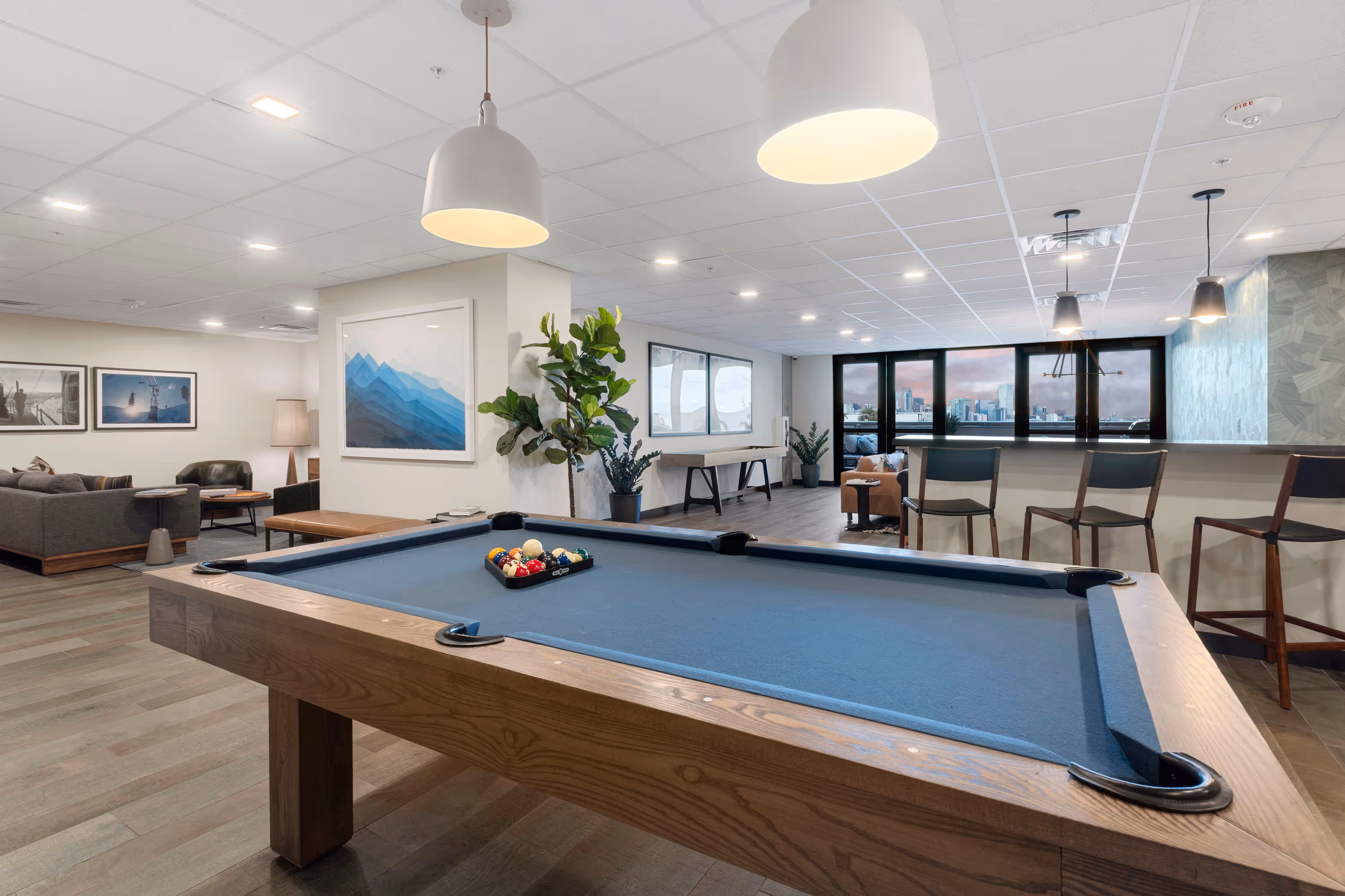 Interior view of the modern gym at The Julian apartments in Sloans Lake, Denver, Colorado, equipped with a variety of fitness machines and a panoramic city view.
