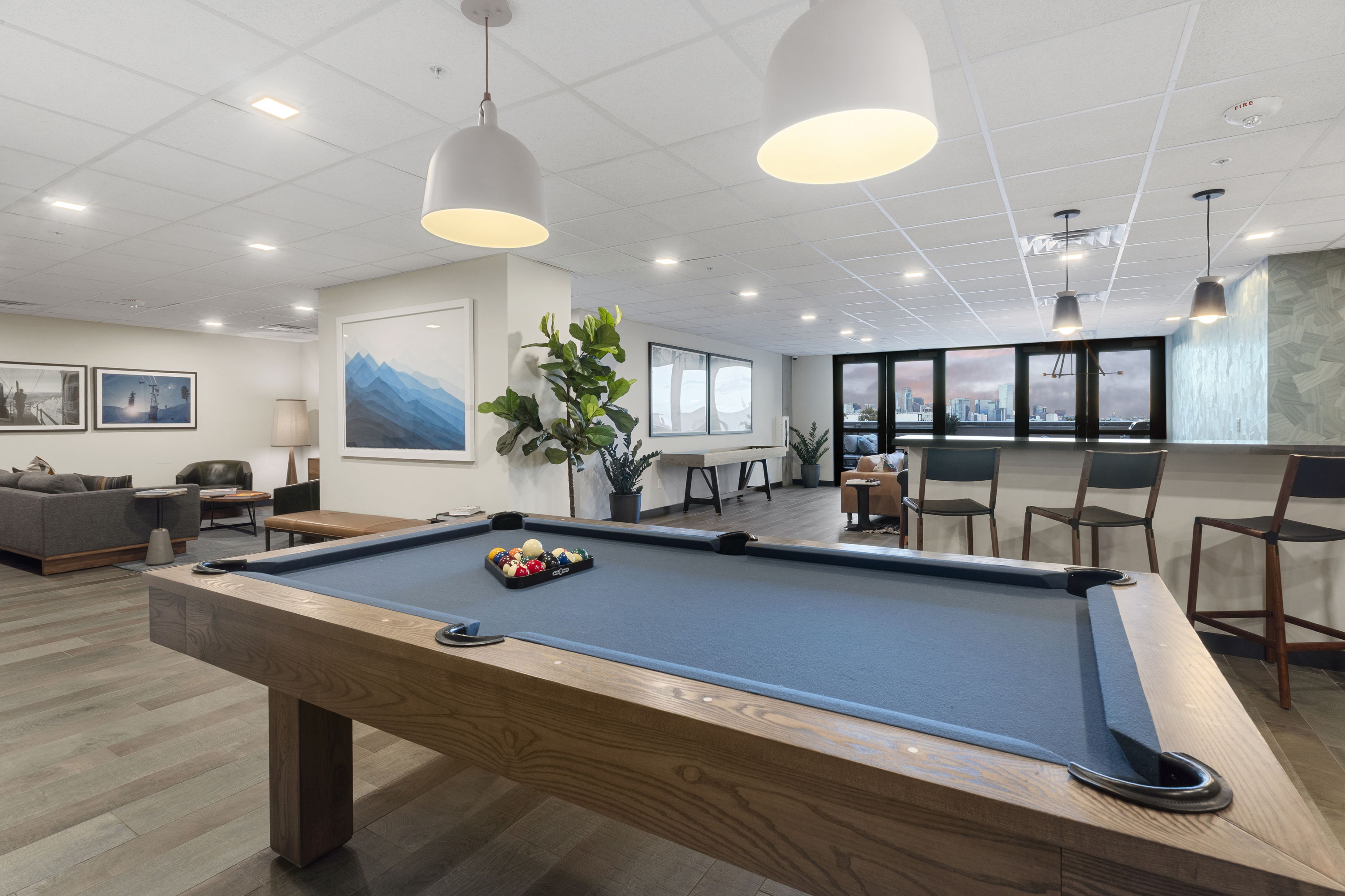 Interior view of the modern gym at The Julian apartments in Sloans Lake, Denver, Colorado, equipped with a variety of fitness machines and a panoramic city view.
