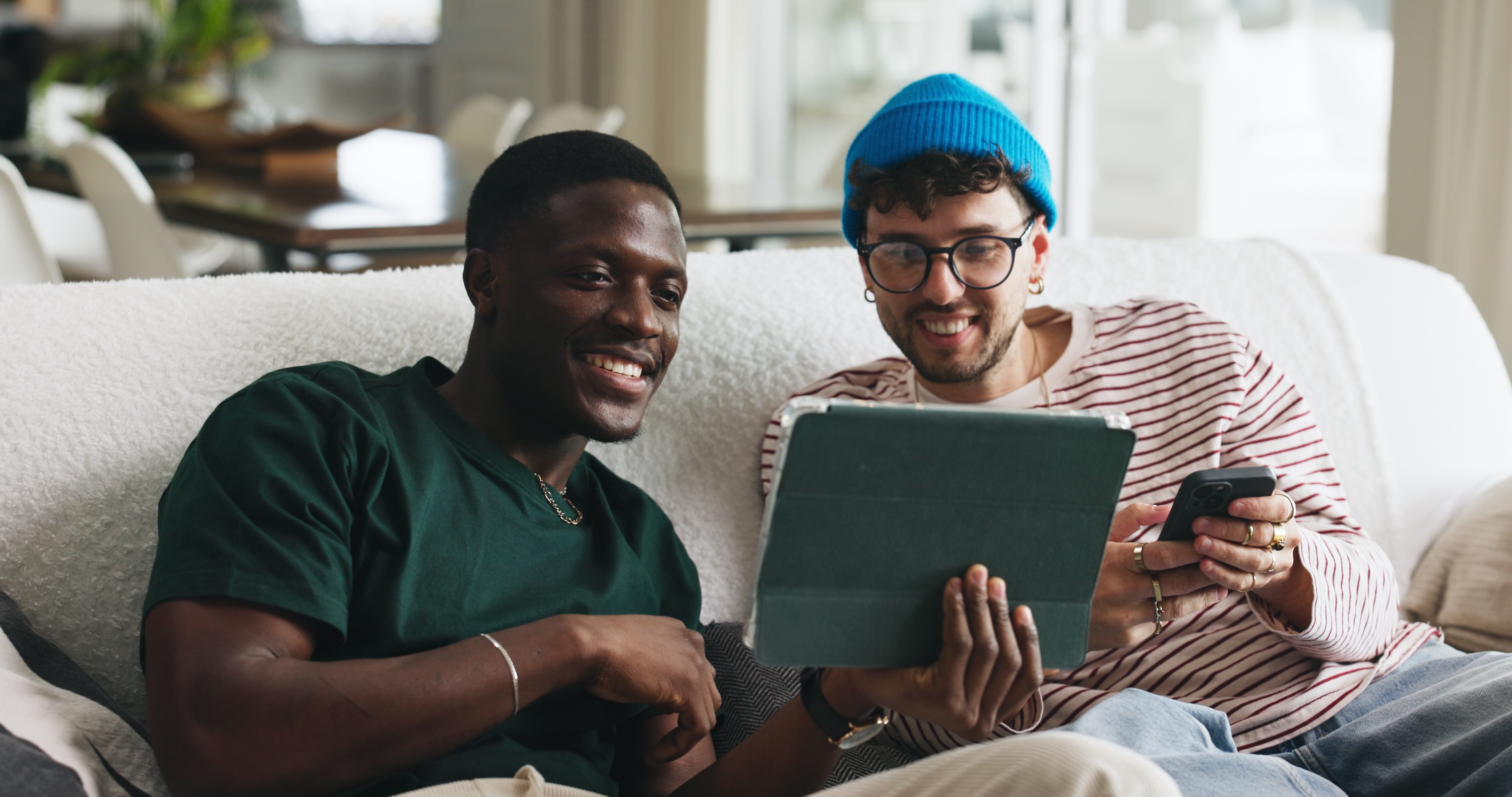 Two people relaxing on a comfortable sofa in a bright, open-concept loft at The Julian.
