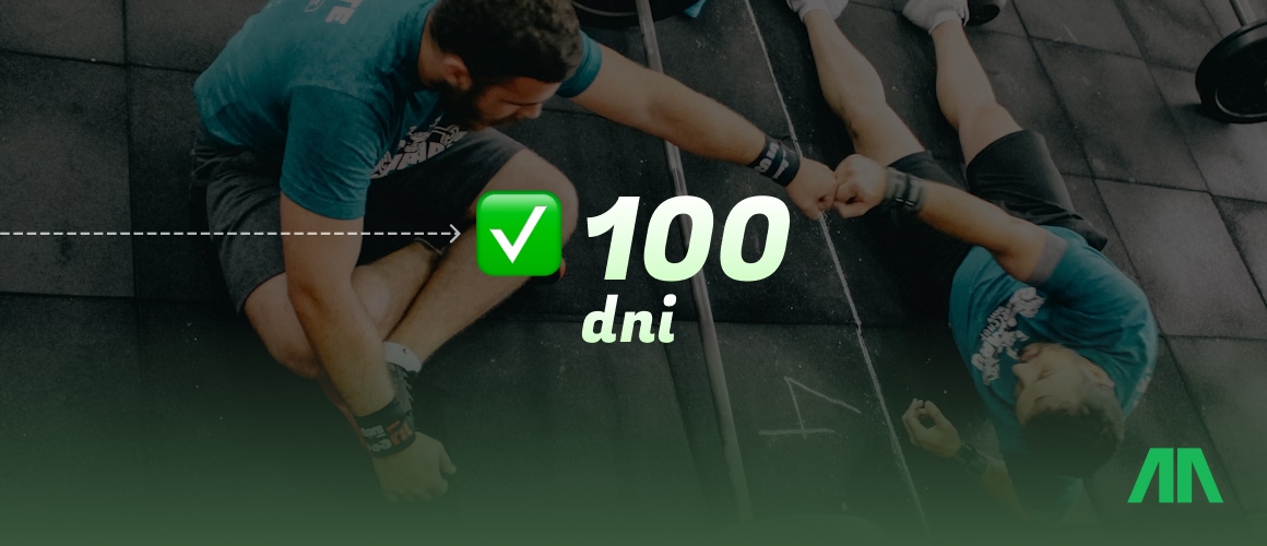 Trener personalny pokazuje na tablecie dane dotyczące postępów treningowych.