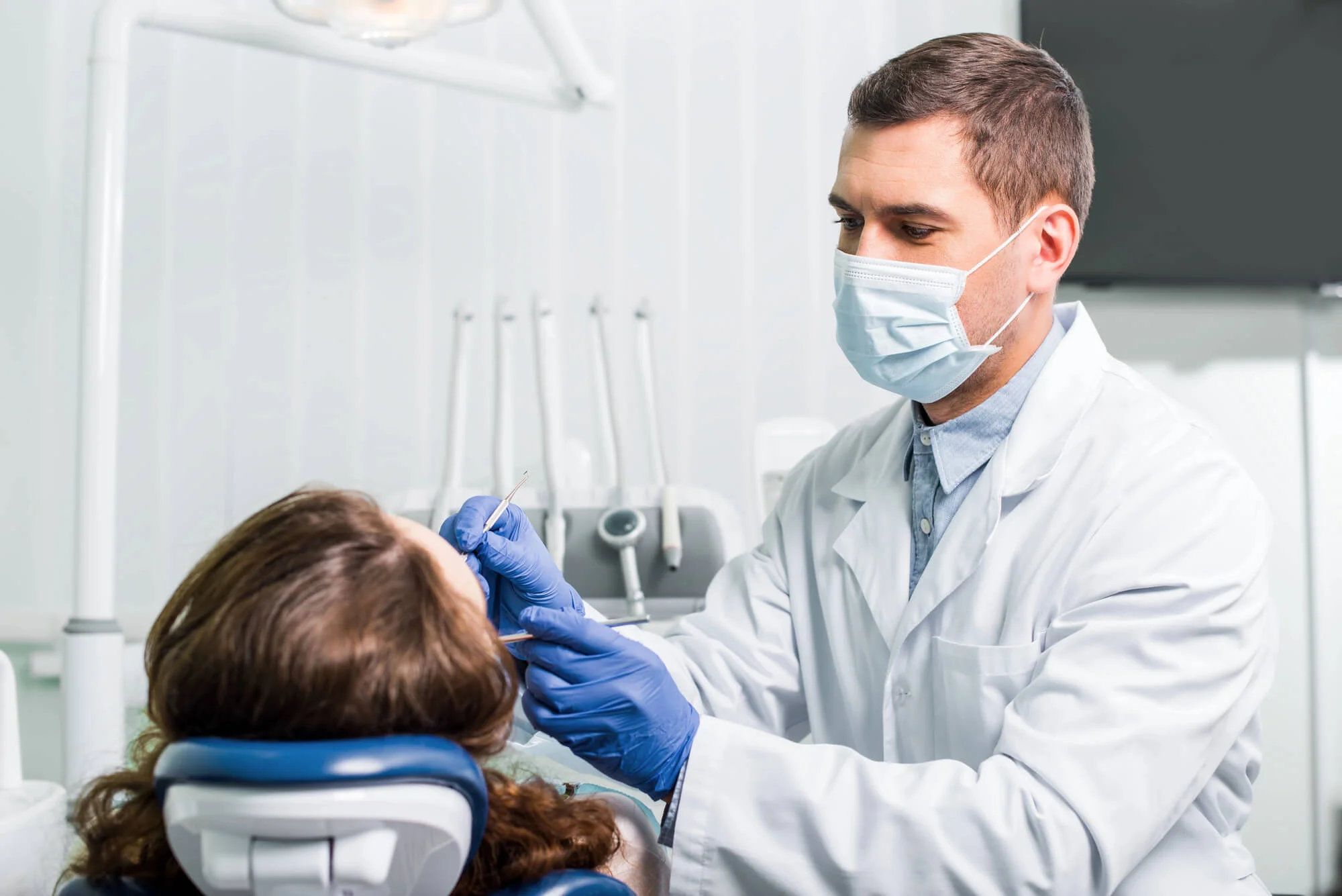 Dentist examining patient in chair dental care in grand prairie tx