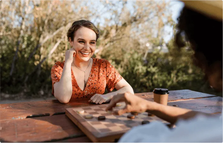Two people playing chess, the picture is focusing on a lady