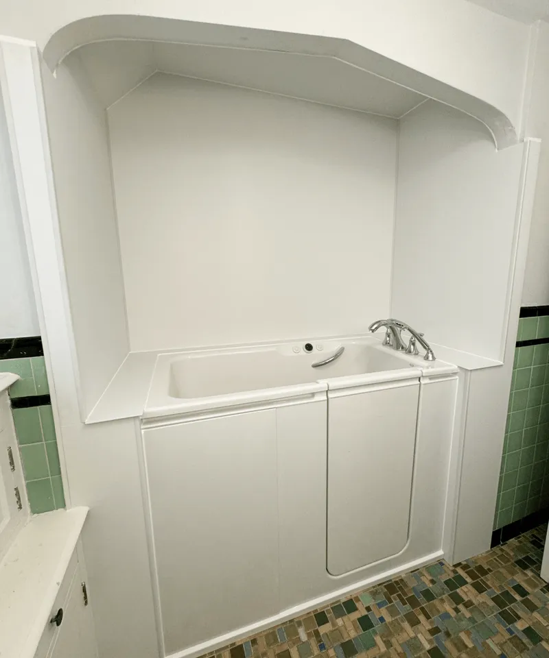 Minimalist Kohler shower remodel with high-end finishes and floor-to-ceiling built-in shelving.