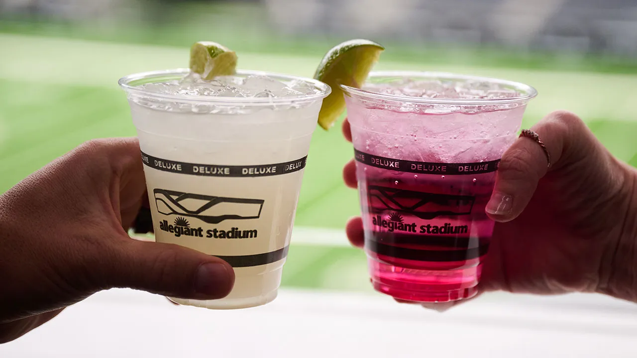 Two hands with cocktail glasses toasting each other