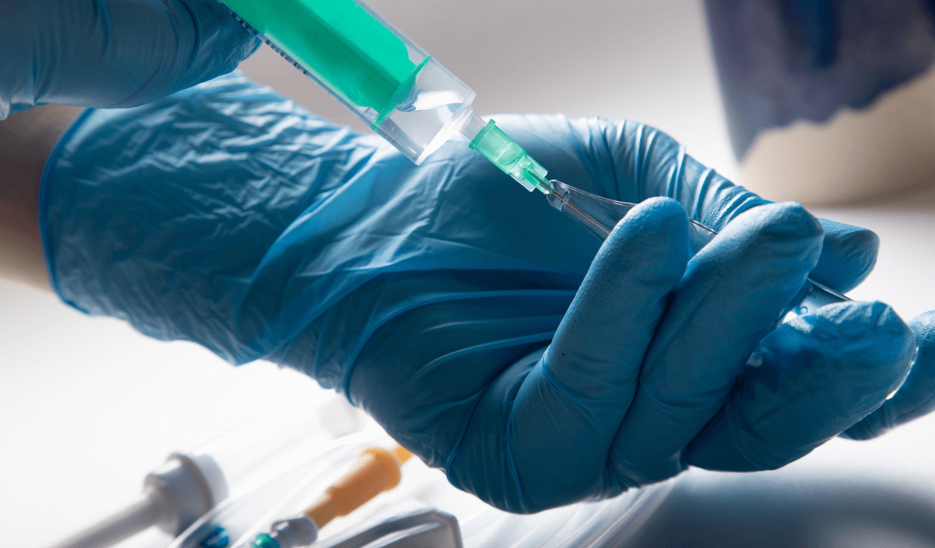 Close-up of a medical professional preparing anesthesia with a syringe, representing care from the best anesthesiologist in San Jose.