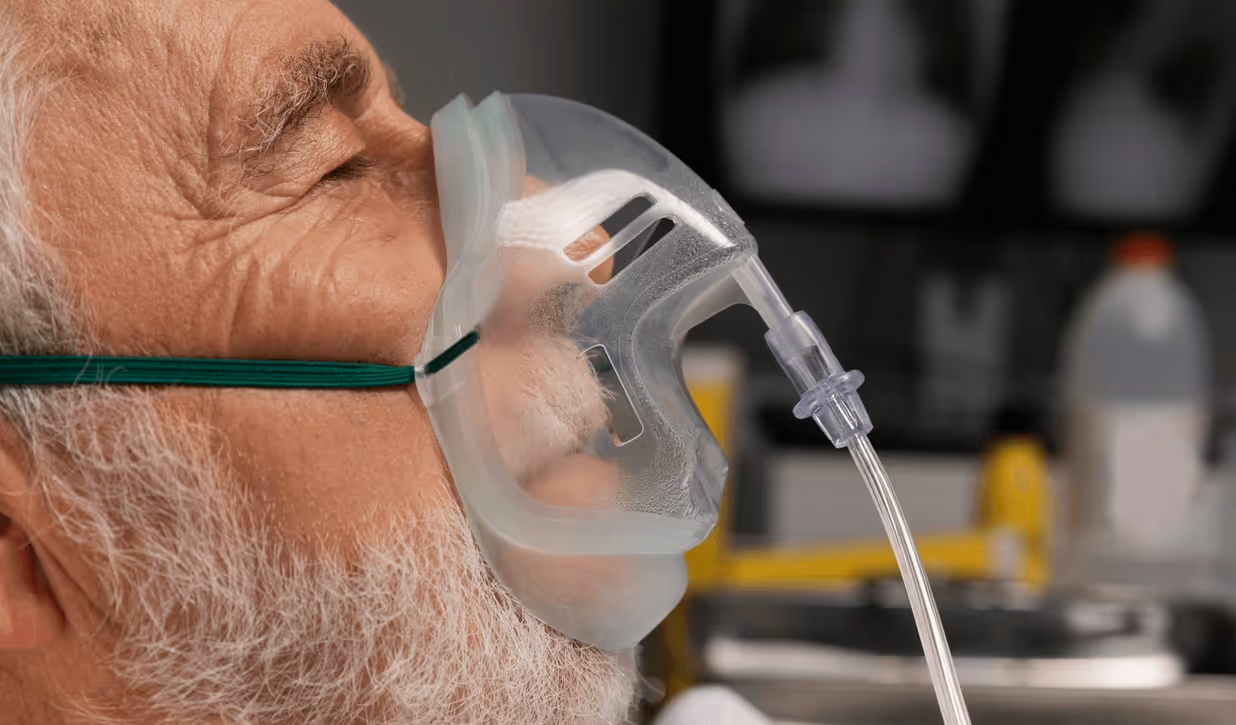 Elderly patient wearing an oxygen mask before anesthesia, illustrating advanced care provided by the best anesthesiologists in San Jose.