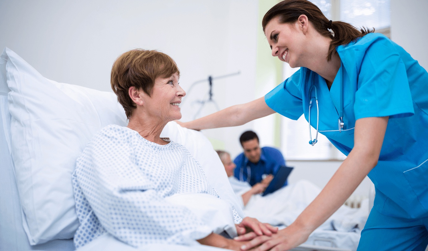 Preparing patient for anesthesia as a caring nurse assists a woman in a hospital bed, highlighting safe preoperative care by the best anesthesiologists in San Jose.