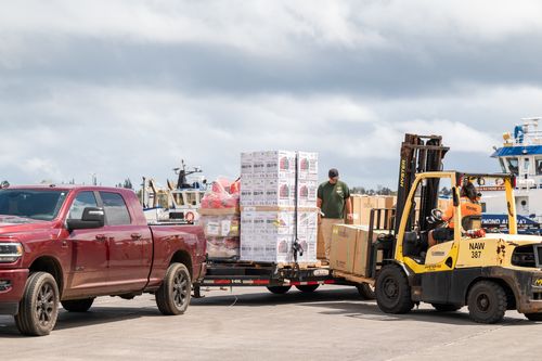 Forklift loading supplies onto a truck at the harbor